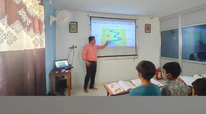 A geography lesson on the projector with students at Ronak Coaching Center